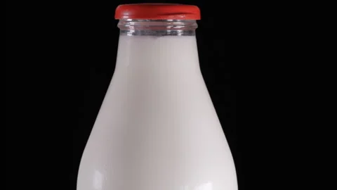 Milk bottle on black background Camera moves smoothly from the bottom to the top Stock Footage 284048410