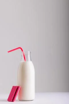 Milk bottle with straw by waffle against white background, copy space Stock Photos