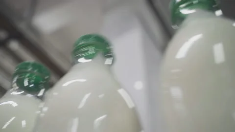 Milk Bottles with Green Caps moving. Manufacturing of Dairy Based Products Stock Footage 168765553
