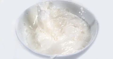 Milk Bowl exploding against White Background Stock Photos