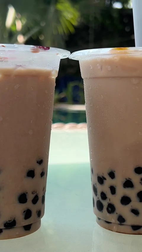 Milk bubble tea with tapioca pearls in glass, gray background. Two Bubble Tea Stock Footage 277677996