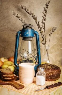 Milk in a ceramic pot, rye bread, cutting board, salt shaker with salt, onion Stock Photos