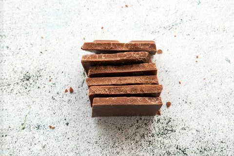 Milk chocolate chunks on light background Stock Photos