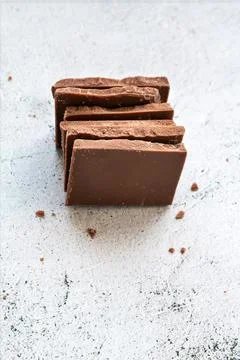 Milk chocolate chunks on light background Stock Photos