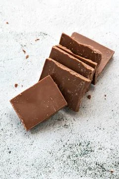 Milk chocolate chunks on light background Stock Photos