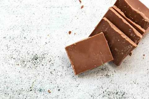Milk chocolate chunks on light background Stock Photos