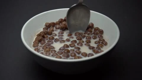 Milk With in Chocolate Corn Balls. Spoon rotates Corn Balls. Slow Motion Stock Footage 86995837