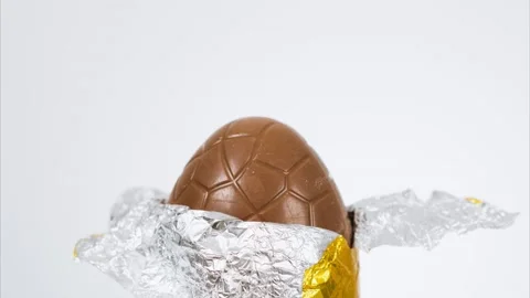 A Milk Chocolate Easter Egg being unwrapped and eaten in stop motion style Vidéo 147952844