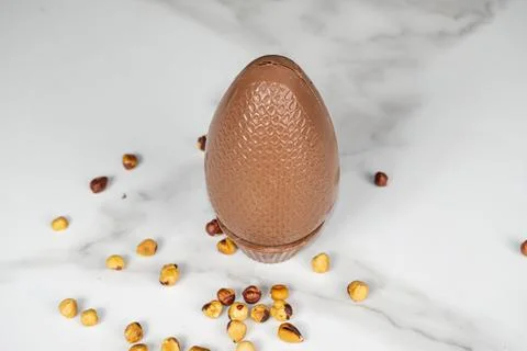 Milk chocolate Easter egg filled with hazelnut cream top view. Stock Photos