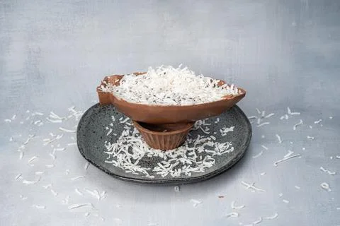 Milk chocolate Easter egg with grated coconut front view. Stock Photos