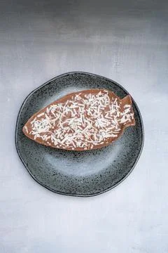 Milk chocolate Easter egg with grated coconut top view vertical. Stock Photos