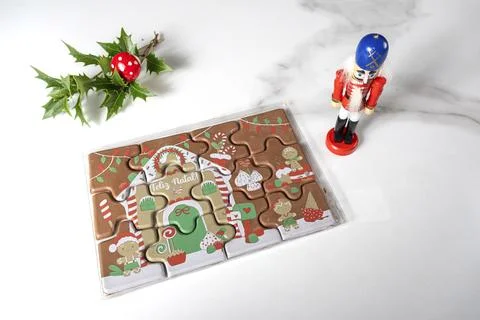 Milk chocolate puzzle next to Nutcracker doll top view. Foto stock