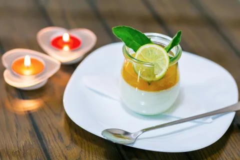 Milk dessert with lime at the table by candlelight Stock Photos
