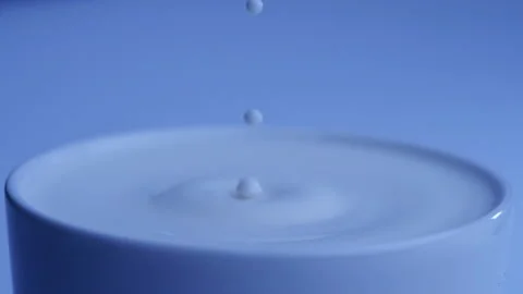 Milk drop falls into the filled cup created ripple wave in slow motion. Stock-Footage 144680076