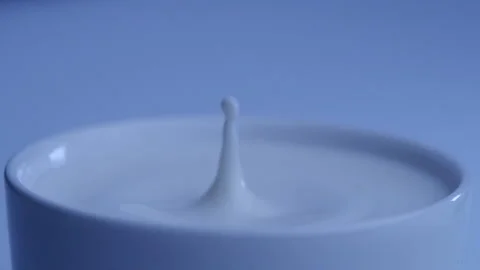 Milk drop falls into the filled cup created ripple wave in slow motion. Stock-Footage 144680095