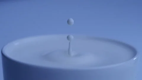 Milk drop falls into the filled cup created ripple wave in slow motion. Stock-Footage 144680096