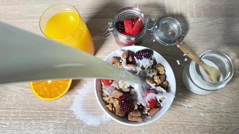 Milk falling into a cereal bowl in slow motion. Top view. Stock Footage 130350035