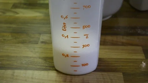 Milk is filled into a measuring cup Stock-Footage 78563947