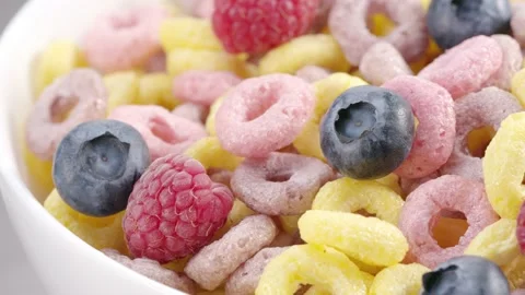 Milk flow pouring into bowl with cereal rings and berries Stock Footage 171888853