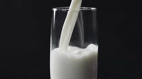 Milk flows into a glass slow motion Stock Footage 153804185