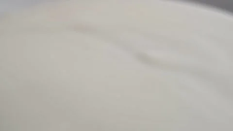 Milk flows in a trickle on a white background in close-up. Stock Footage 278208668