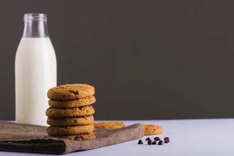 Milk in glass bottle with cookies against gray background, copy space Stock Photos