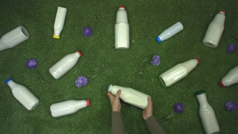 Milk on the grass. Top view. Slow motion 2x. Stockbeeldmateriaal 122588063