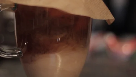 Milk Mixing in With Coffee Through a Filter Stock Footage 85991021