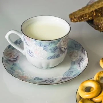 Milk in a mug on the table with bread, drying or apples Stock Photos