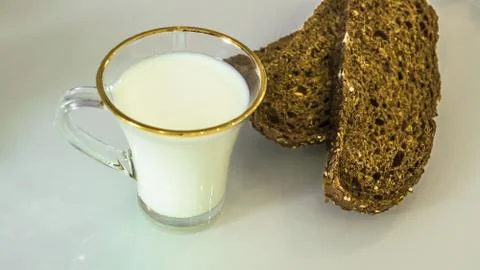 Milk in a mug on the table with bread, drying or apples Stock Photos