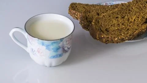 Milk in a mug on the table with bread, drying or apples Stock Photos