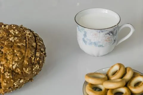 Milk in a mug on the table with bread, drying or apples Stock Photos