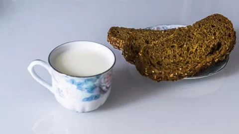 Milk in a mug on the table with bread, drying or apples Stock Photos