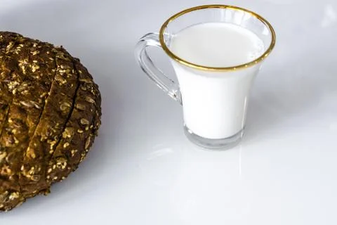 Milk in a mug on the table with bread, drying or apples Stock Photos