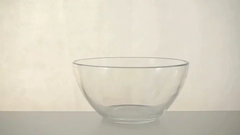 Milk is poured and splashed in slow motion in a  bowl on a white background. Stock Footage 131020947