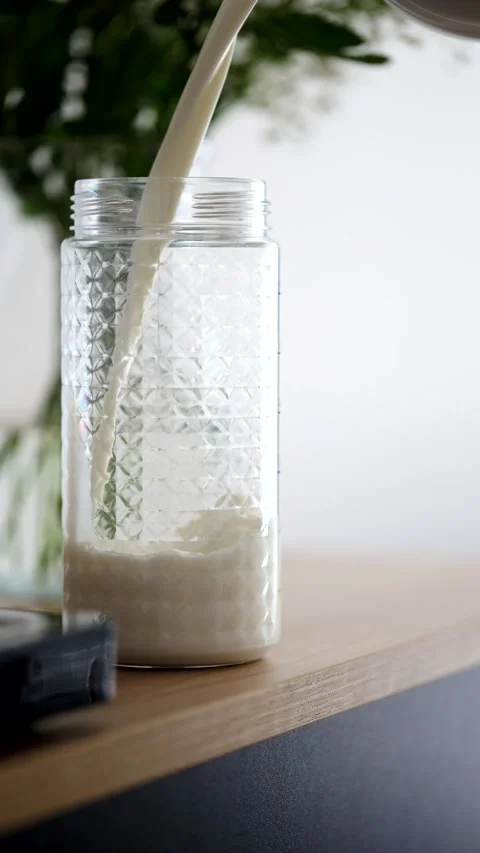 Milk is poured into a beautiful embossed bottle Stock Footage 279063973