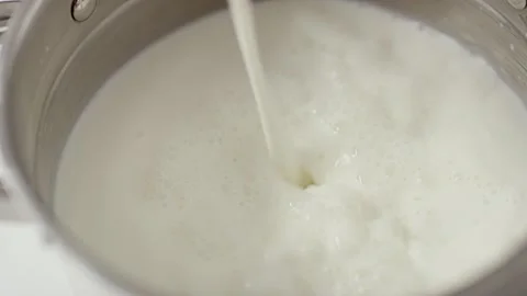 Milk is poured into a bucket Stock Footage 156508442