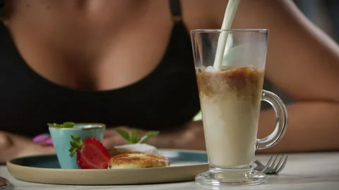 Milk is poured into a cup of coffee Stock Footage 204025807