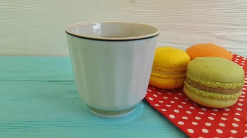 Milk is poured into a cup of coffee, macaron, slow-motion Stock Footage 86322686