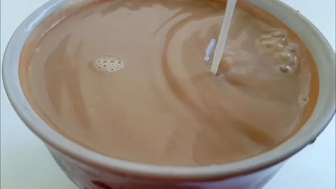 Milk is poured into the cup slow-motion Stock Footage 88529399