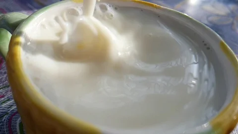 Milk is poured into the cup slow motion Stock Footage 89255526