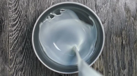 Milk is poured into a deep dish. Stock Footage 67647177