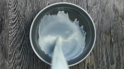 Milk is poured into a deep dish. Stock Footage 67647227