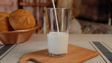 Milk is poured into a glass Stock Footage 154235325