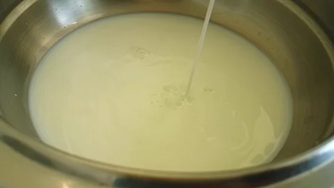 Milk is poured into a pan Stock Footage 87876875