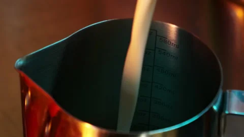 Milk is poured into a pitcher. Slow motion Stock Footage 183127987