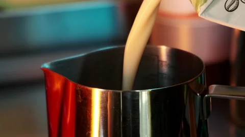 Milk is poured into a pitcher. Slow motion. Stock Footage 183128086