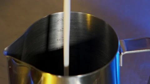 Milk is poured into a pitcher. Slow motion. Stock Footage 183968869
