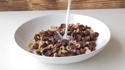 Milk is poured into a plate with cornflakes in slow motion 4k. Breakfast Stock Footage