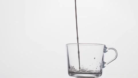 Milk is poured into a transparent cup on a white background. Stock Footage 233031876